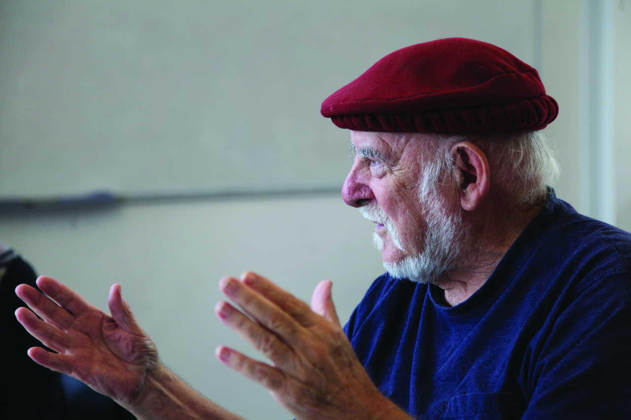 A side profile of a man with both hands extended
