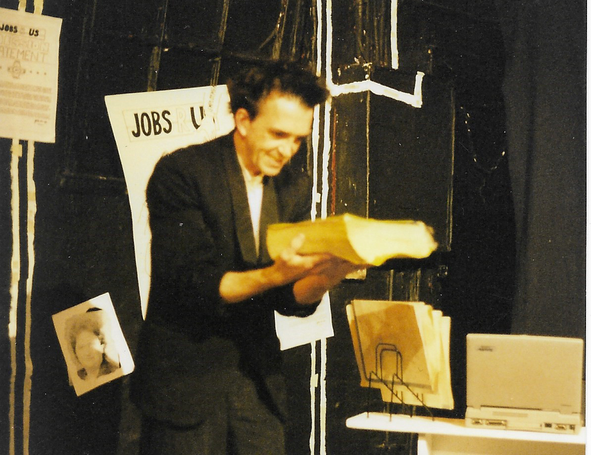 a man standing staring at a big book in his hands