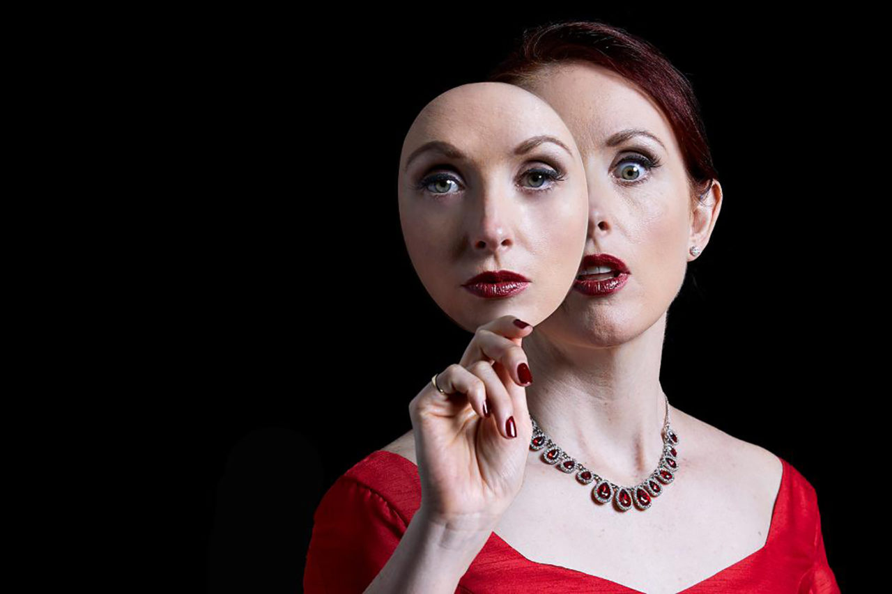a woman holding a double of her face