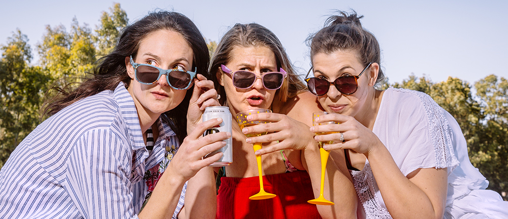 Three women with sunnies on drinking alcohol