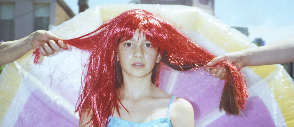 a young person in a long red wig.