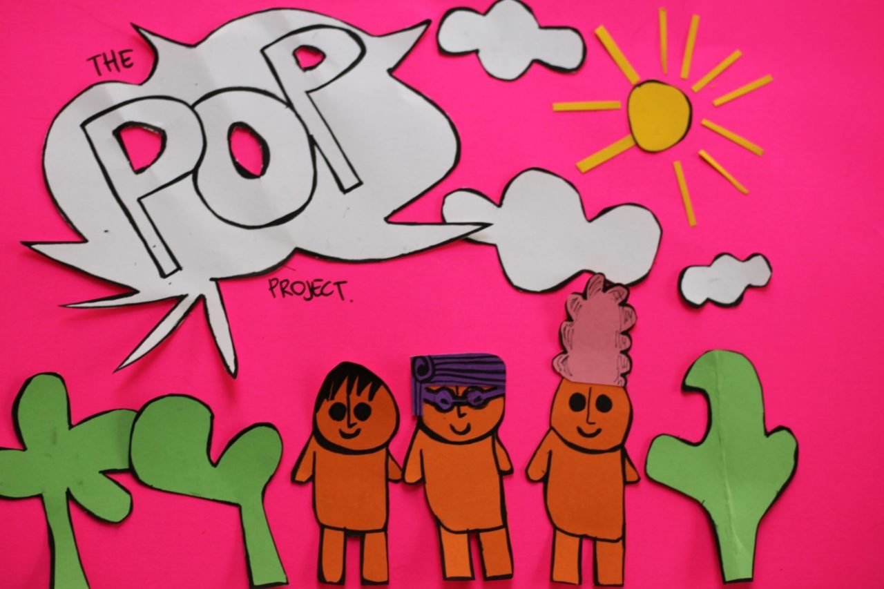An illustration with three figures, trees, clouds and a sun on a pink background with the words The Pop Project