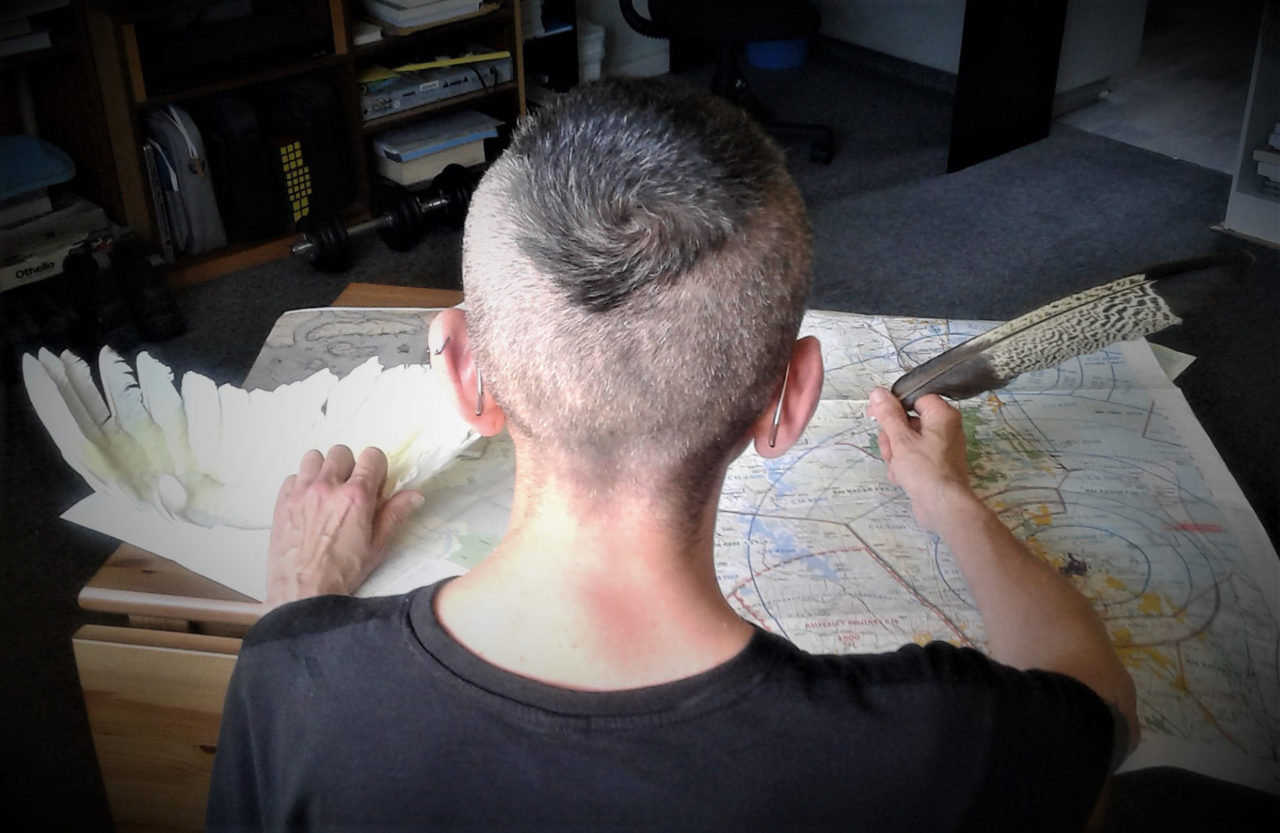 The back of a shaved head looking over a map