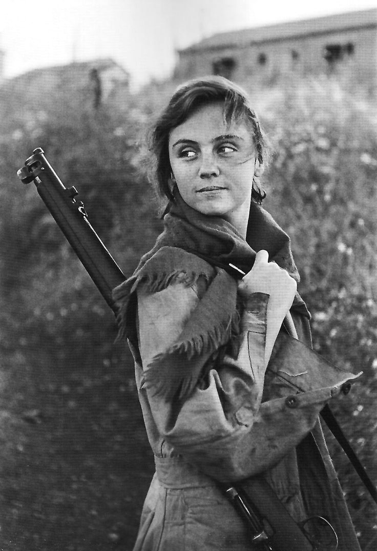 A black and white image of a Spanish militia woman with a machine gun over her shoulder