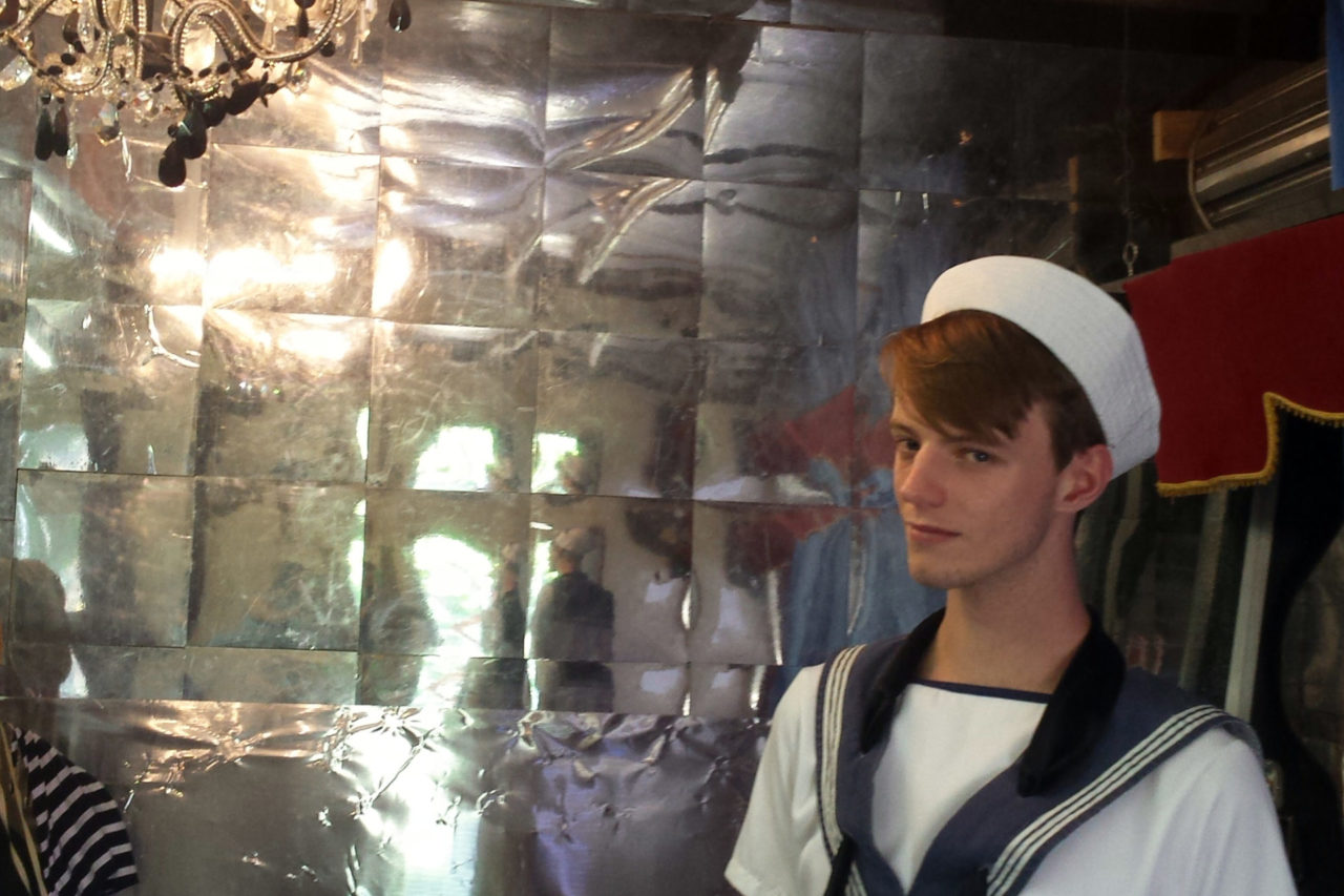 Young man in sailor suit in Venetian interior