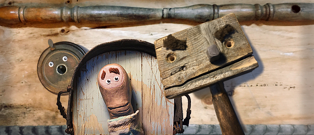 Amongst some salvaged wood, a trio of wooden puppet characters look nervously at each other