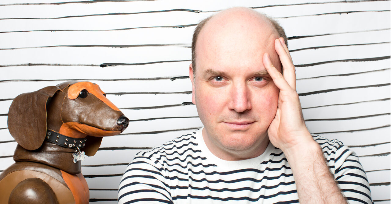 a bald man with a puppet dog