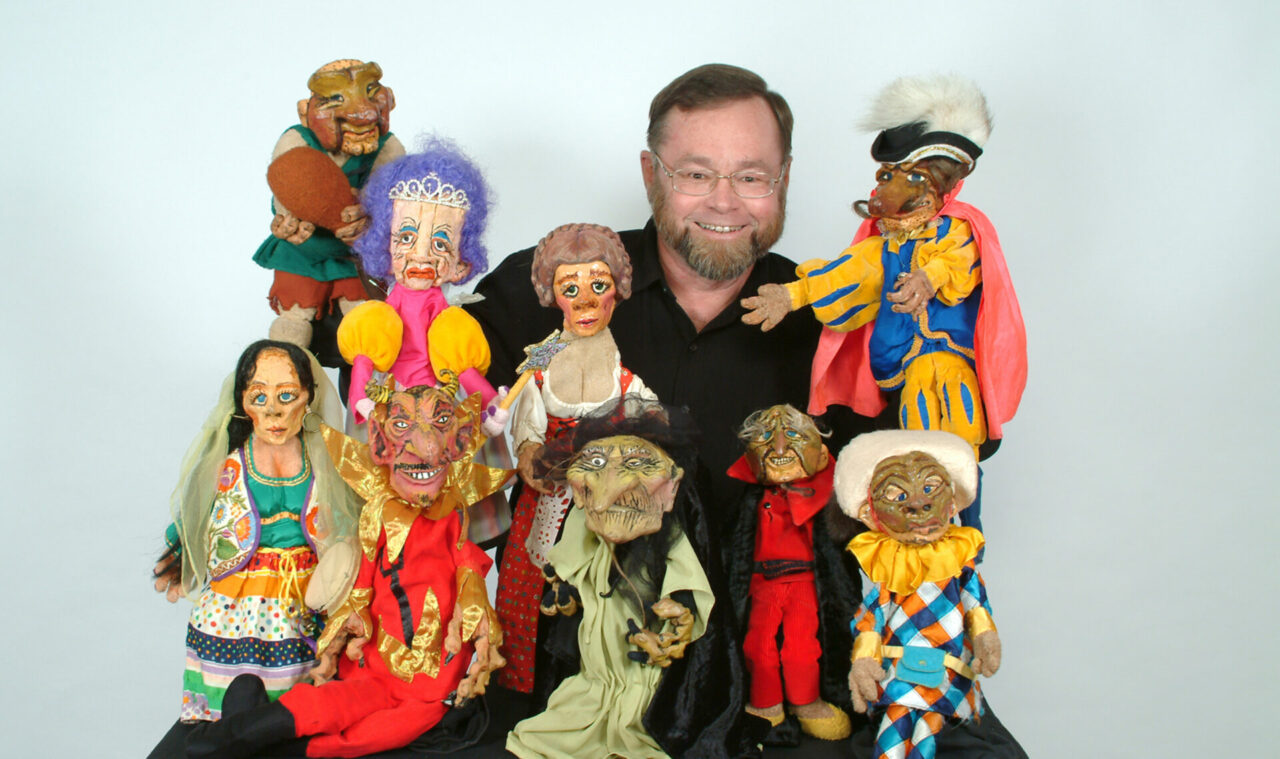 A picture of a man surrounded by puppets