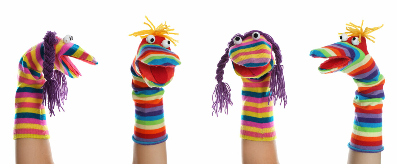 Four rainbow sock puppets looking in different directions.