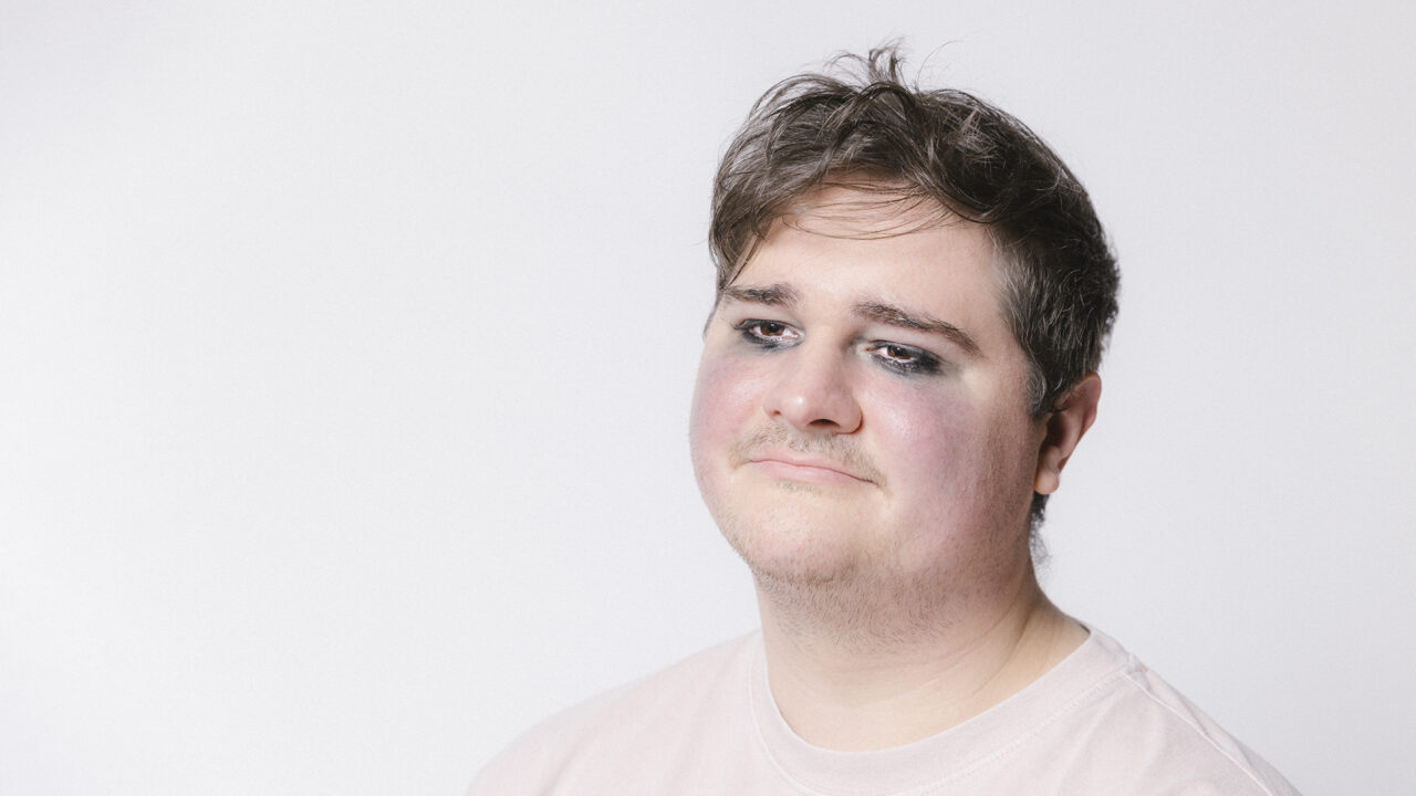 A man poses for a high school photo wearing
